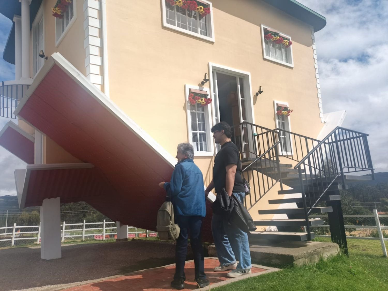 Visitantes frente a una casa con arquitectura invertida
